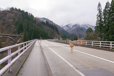 Footbridge over road against sky