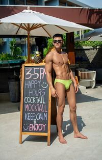 Portrait of young man standing against wall