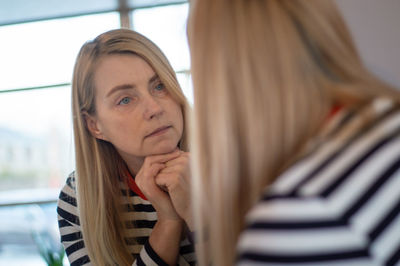 Mature woman looking at mirror