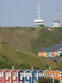 Houses by buildings against sky in city