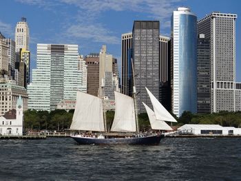 Sailboat on river against financial district