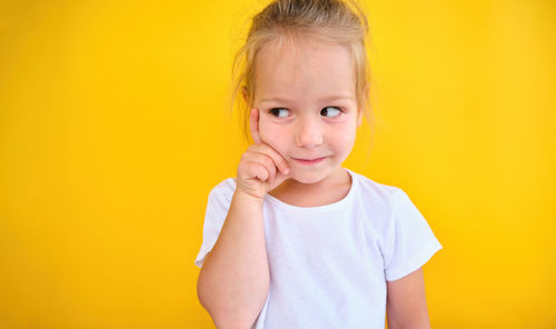 Close-up of cute baby boy against yellow background