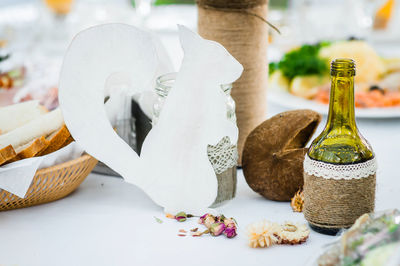 Holiday table decorations made of wooden squirrel figurines, flowers and bottles. 