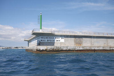 View of lighthouse by sea against sky