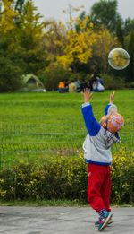 Full length of girl playing on grassy field