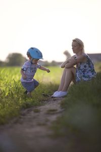 Rear view of boy playing with ball on field