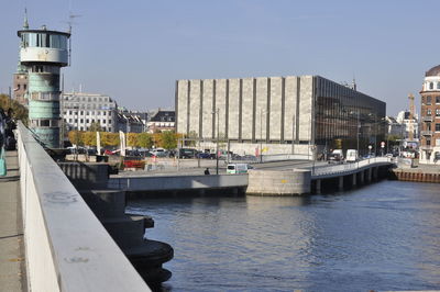 Sailboats on river by buildings against sky in city