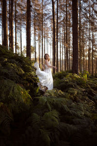 Woman in a forest wearing a white dress 