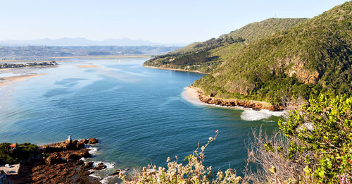 High angle view of sea and mountains against clear sky