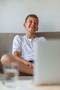 Portrait of happy boy sitting on table