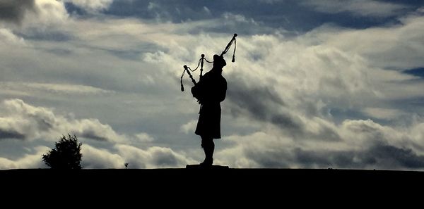 Silhouette man standing against cloudy sky