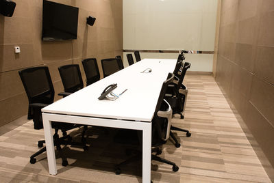 Tables and chairs on hardwood floor at board room