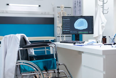 Rear view of woman using laptop at clinic