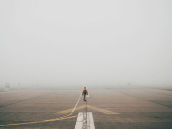 Man walking on tempelhofer feld in fog