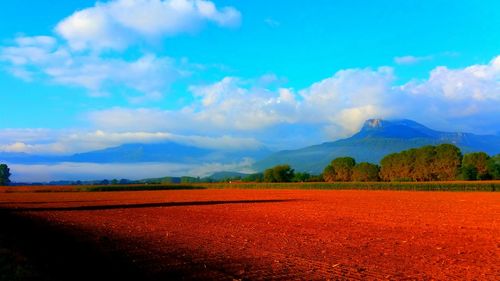 View of fields against cloudy sky