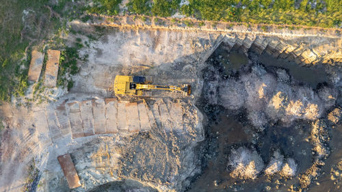 Yellow tracked bulldozer performs earthworks - aerial view shot. yellow tractor rakes the ground