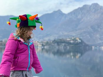 Cute girl wearing headwear against lake