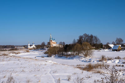 Buildings against clear blue sky during winter