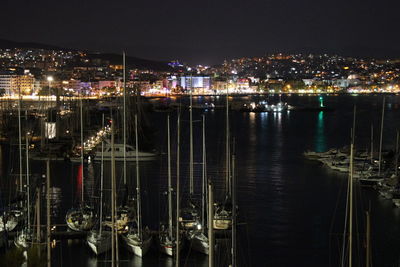 High angle view of illuminated harbor against buildings at night