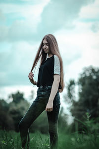 Full length of young woman standing on field