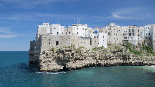 High angle view of buildings on cliff by sea