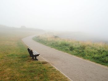 Bench in the fog by coastal path