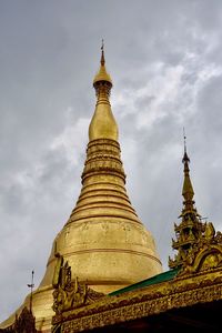 Low angle view of statue of temple against cloudy sky