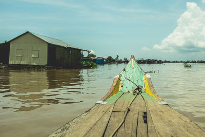 Wooden posts in lake against sky