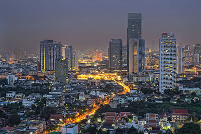 Illuminated buildings in city against sky at night