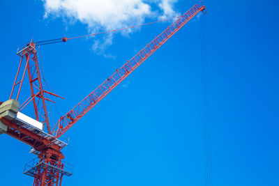 Low angle view of crane against blue sky