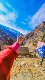 Midsection of person against mountains against sky