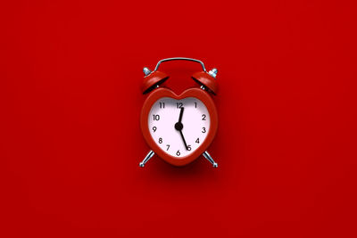 Close-up of clock against red background