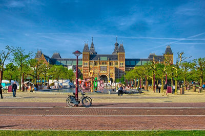 People on street by buildings against sky