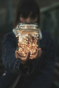 Close-up of woman holding jar of fairy lights