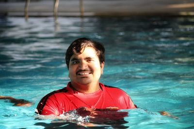 Portrait of smiling man swimming in pool