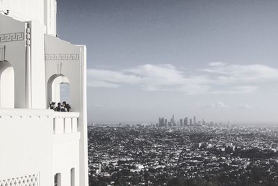 View of cityscape against cloudy sky