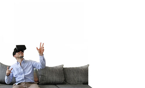 Full length of man sitting on sofa