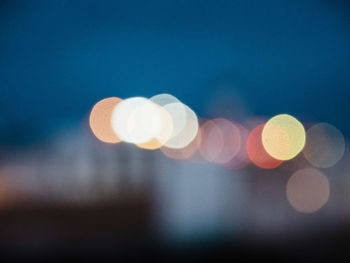 Defocused image of lights against sky at night