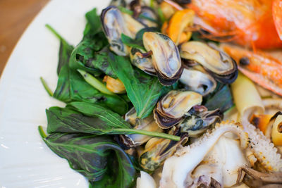 Close-up of seafood with leaf vegetable in plate