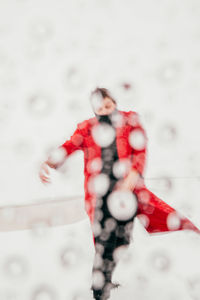 Full length of woman with arms raised in snow