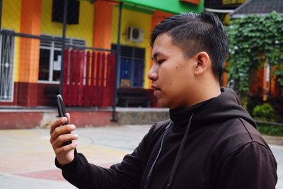 Close-up of young man using mobile phone