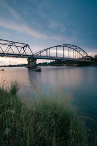 View of bridge over river against cloudy sky