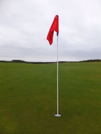 Panoramic view of grassy field against cloudy sky