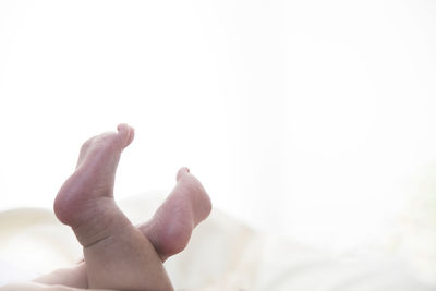 Low section of baby on bed