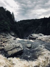 Scenic view of rocky shore against sky