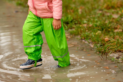 Low section of child walking in puddle