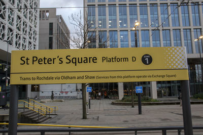 Information sign on street against buildings in city