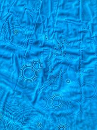 Close-up of water drops on blue surface