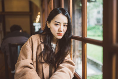 Portrait of young woman in window