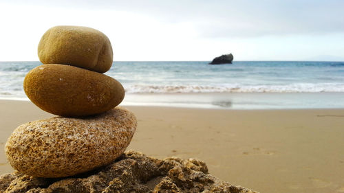 Close-up of stones on beach against sky